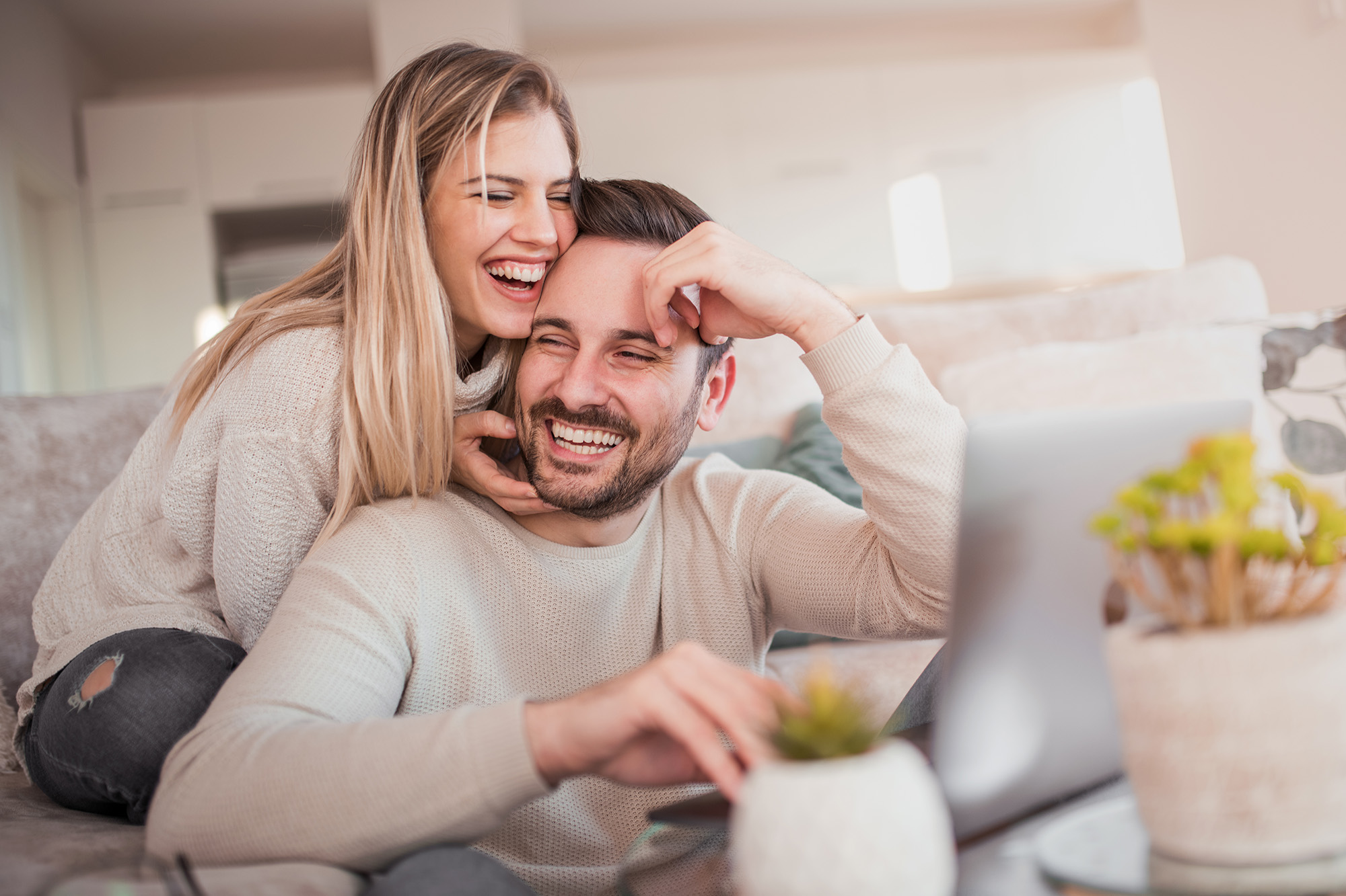 Happy young couple with laptop at home